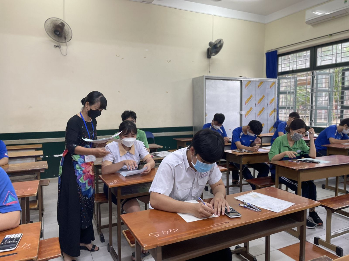 Thí sinh nhận giấy nháp tại một điểm thi tại TP Hồ Chí Minh sáng 8/7.